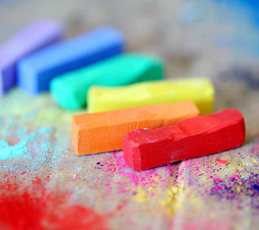 assorted colored chalks on wood surface